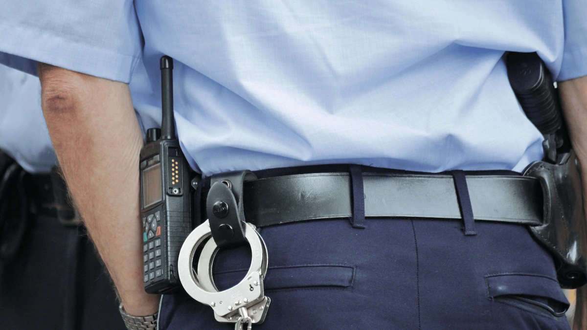 Nahaufnahme eines Polizeigürtels mit Funkgerät, Handschellen und Waffenholster
